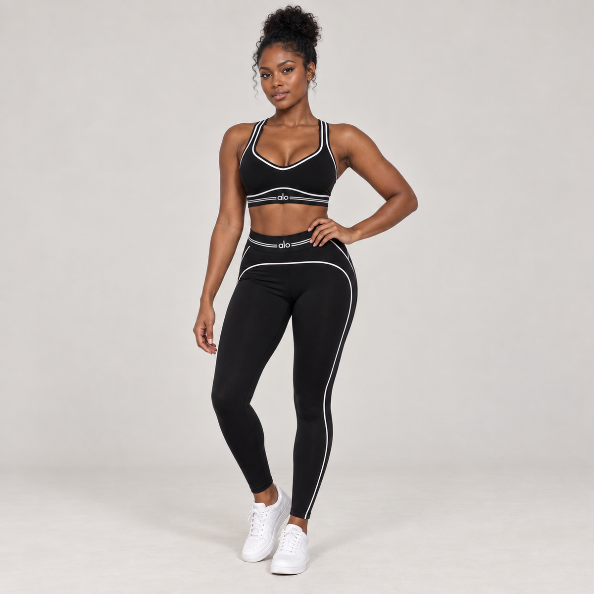 Alo Yoga women's black sports bra and leggings set with white contrast piping, shown on an AI-generated model